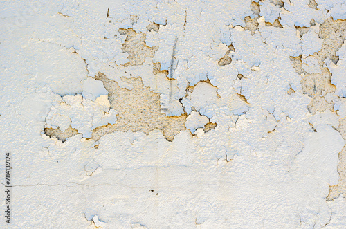 Close-up of peeling paint on an exterior stucco wall of a vintage building.