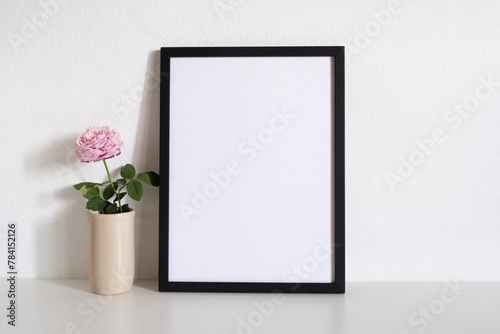 mock up black frame picture with flower on table