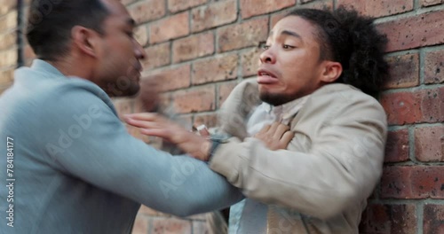 Angry man, thief and punching face with fist on wall for fight, beat or abuse in city alley. Frustrated male person hitting scared opponent in attack or struggle under pressure with outdoor bully