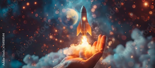 Startup business concept, rocket launching upward from the bottom of the hand. Clouds and smoke, space background. 
