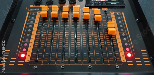 Close up orange button of sound mixer panel equipment for mixing or control audio system with selective focus technique. Technology, Tool and Digital device concept.
