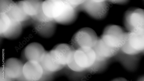 Blurred white Bokeh of light on black background. Lighting blurry wallpaper.