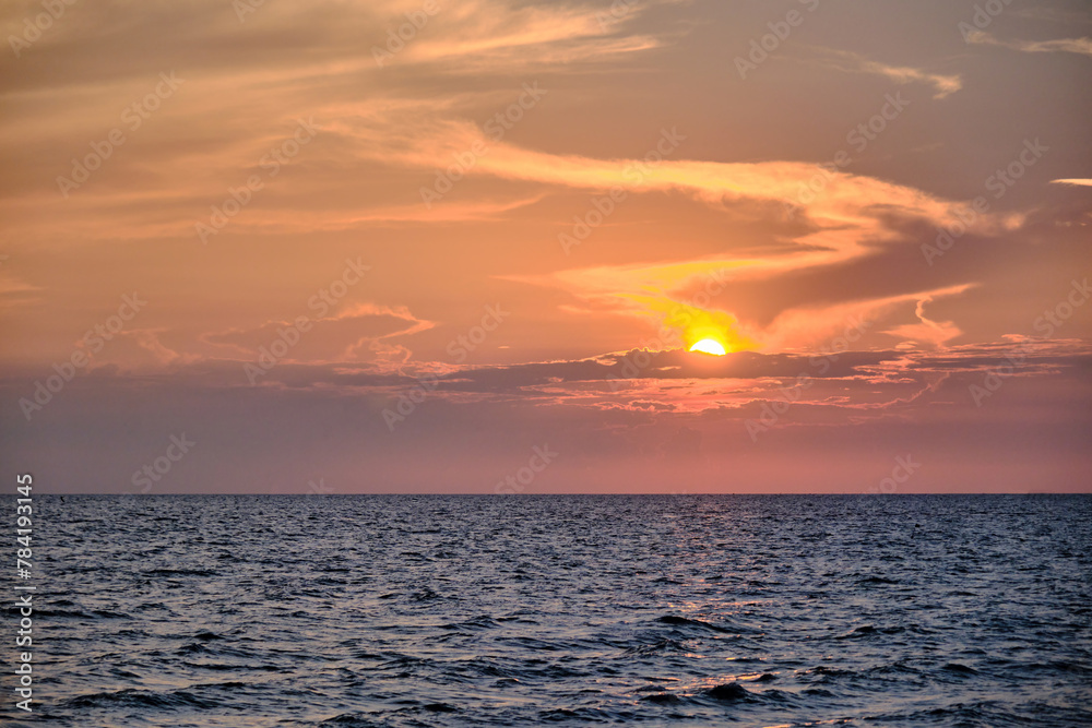 red twilight sky of sunset scene with cloudy sky over the open ocean with many waves