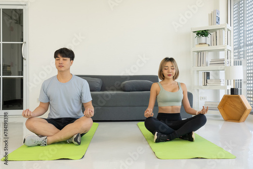 Young Asian Couple Doing Yoga at Home Together