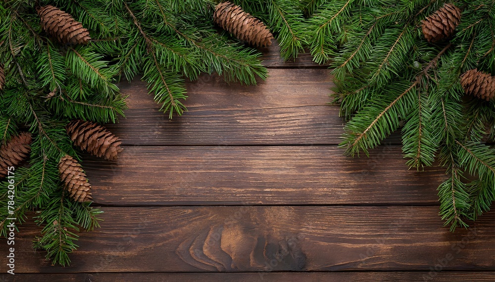 Wooden brown background with a frame of green fir twigs