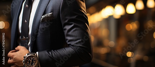 close up businessman in a black suit is glancing at his watch to see the time photo