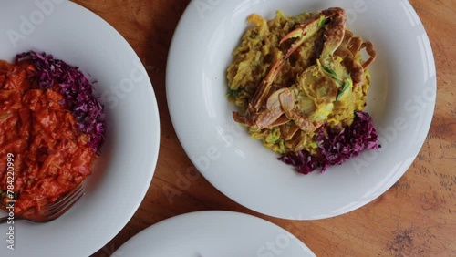 Sri Lankan Crab Curry on the white plate and wooden background. Modern cuisine of Sri Lanka. Colorful sea food dishes