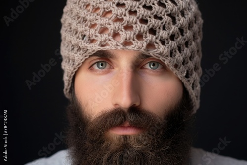 Close-up portrait of a bearded guy in an openwork knitted hat photo