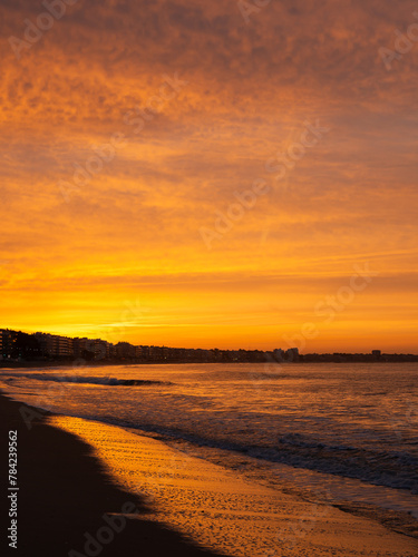 Amazing view of a fiery sunrise with multicolored clouds. Sea waves along the seashore at sunrise. Morning time. Ocean view. La Baule-Escoublac  France