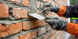 Masonry works A person working in the construction of a building Bricklayer laying bricks on mortar on new residential 