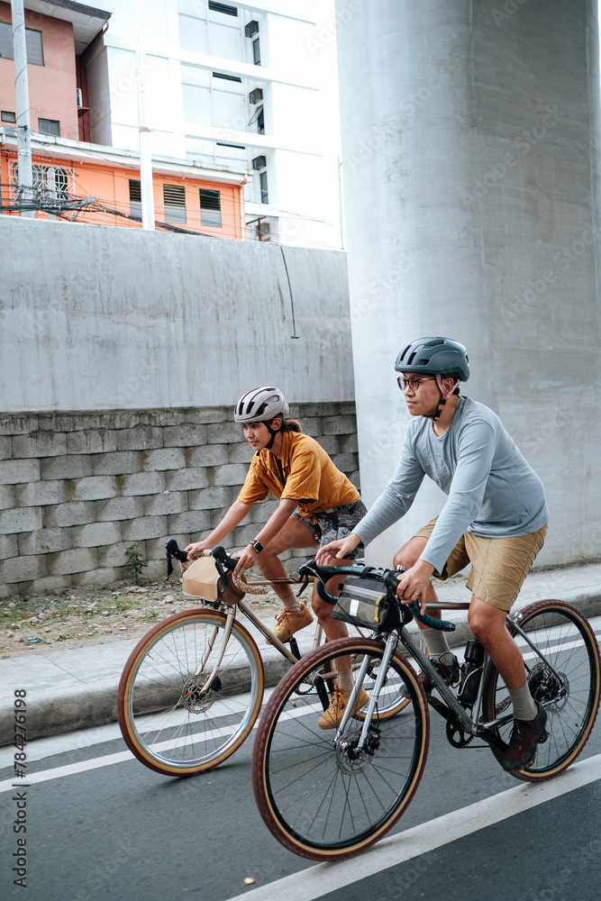 Fototapeta premium A couple is cycling in the city during summer time.