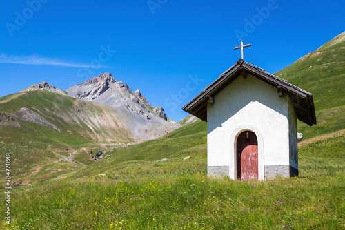 Small chapel on green alpine meadow in France.