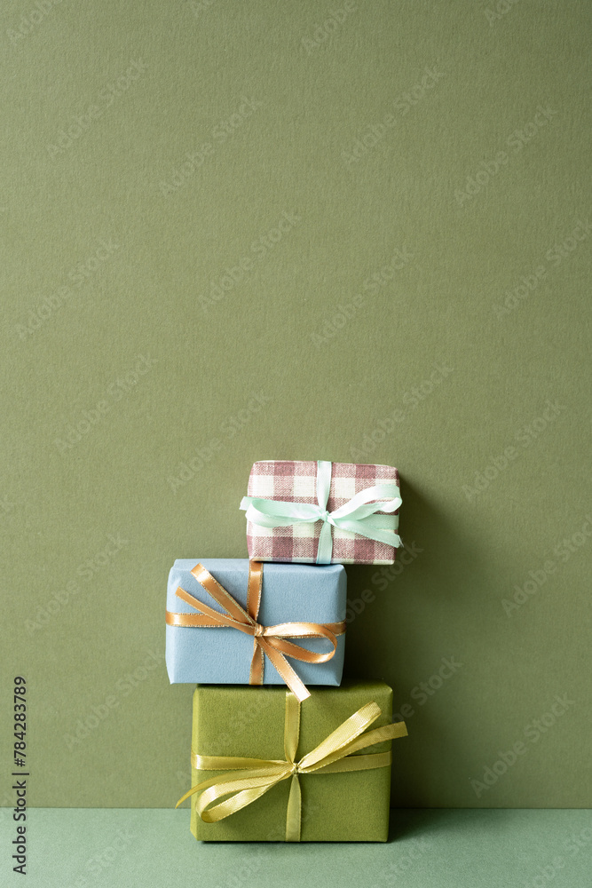 Stack of gift box on green table. khaki wall background. anniversary celebration concept