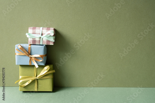 Stack of gift box on green table. khaki wall background. anniversary celebration concept