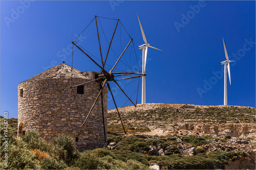 Alt trift auf neu, eine alte griechische Windmühle neben einem neuen weißen Windrad auf Naxos photo