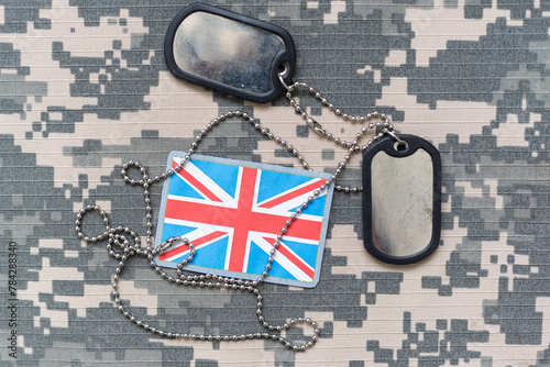 army blank, dog tag with flag of great britain on the khaki texture background. military concept photo