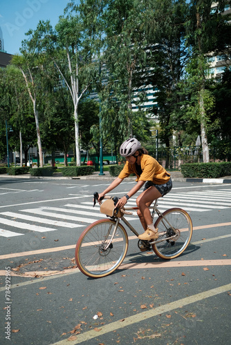A young woman is cycling in the city during summer time.