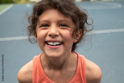 Young hispanic girl laughing while playing sports outside