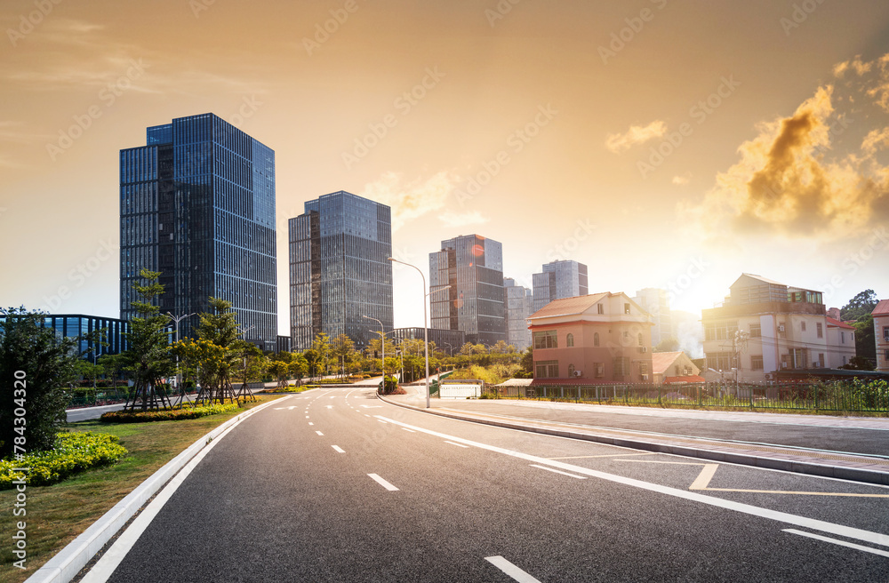 Empty asphalt road near office buildings