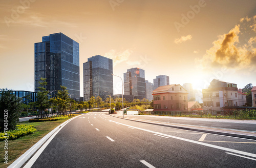 Empty asphalt road near office buildings