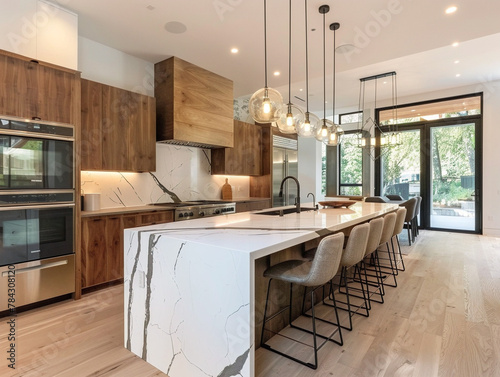 Modern kitchen with sleek waterfall edge counter, stainless steel appliances, and minimalist design aesthetic.