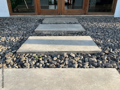 Rectangle stepping stones with gravel stone pebbles floor leading towards building entrance