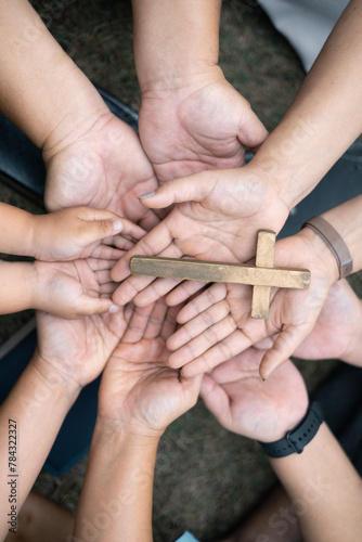 Group of Christian believers clasped hands in prayer, In the church, expressing their faith through worship and reverence for God, symbolized by the cross. Group christian pray concept.