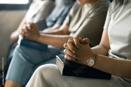 Group of Christian women sat together in chairs  holding their Bibles  feeling the togetherness of prayer and their religious connection to God. Group christian pray concept.