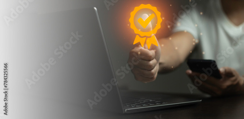 A person is holding a cell phone and a laptop, with a check mark on the laptop