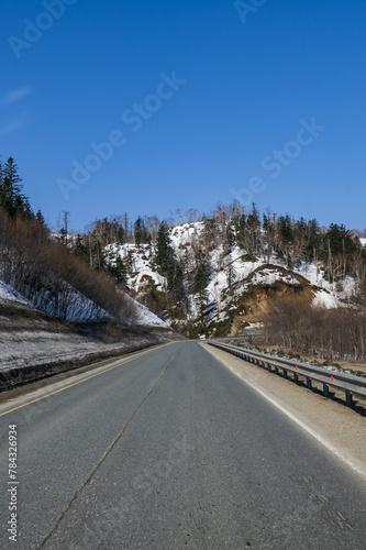 Scenery of the road in the mountains with snow and blue sky © Алексей Линник