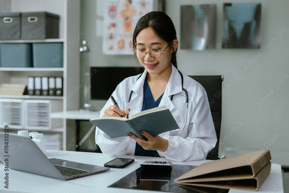 Doctor sitting at table and writing on a document report in hospital office. Medical healthcare staff and doctor service. Doctor sitting at table and writing on a document report in hospital office. Medical healthcare staff and doctor service.