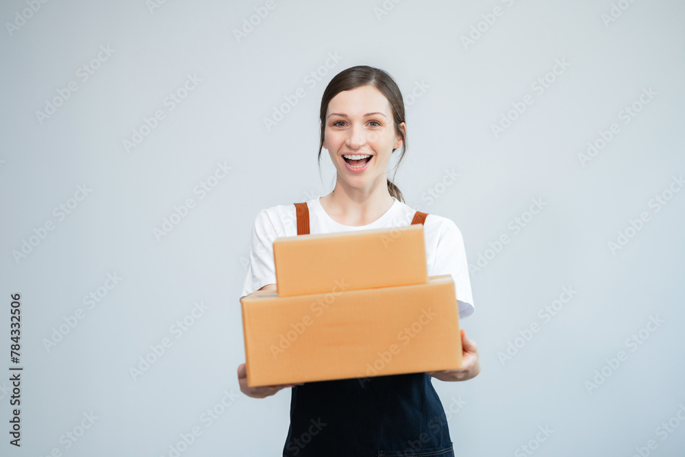 woman start up small business owner writing address on cardboard box at workplace.small business entrepreneur SME or freelance asian woman working with box at home. woman start up small business owner writing address on cardboard box at workplace.small business entrepreneur SME or freelance asian woman working with box at home.