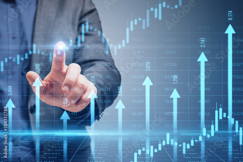 Close up of male hand pointing at growing blue vertical arrows and candlestick forex chart on blurry index grid background. Economic growth and increase concept. Double exposure.