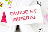 Latin quote Divide et impera meaning Divide and conquer. the best method of governing such a state is to incite and use hostility between its parts. Text written on a white card