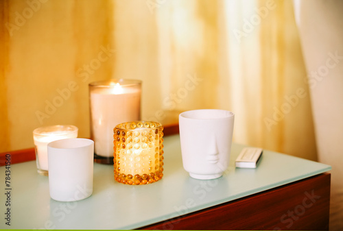Valokuva Table with many burning lighting scented candles and aromatic incense sticks in spa massage salon or yoga studio, selective focus