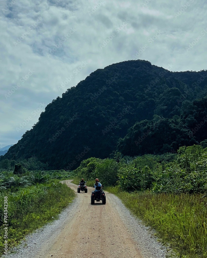 Vertical shot of people driving on a road in the mountains Vertical shot of people driving on a road in the mountains