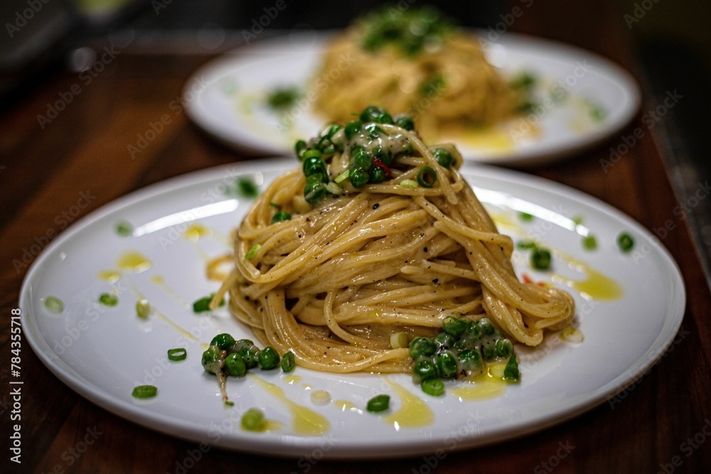 Closeup shot of spagetti with green onion and peas
