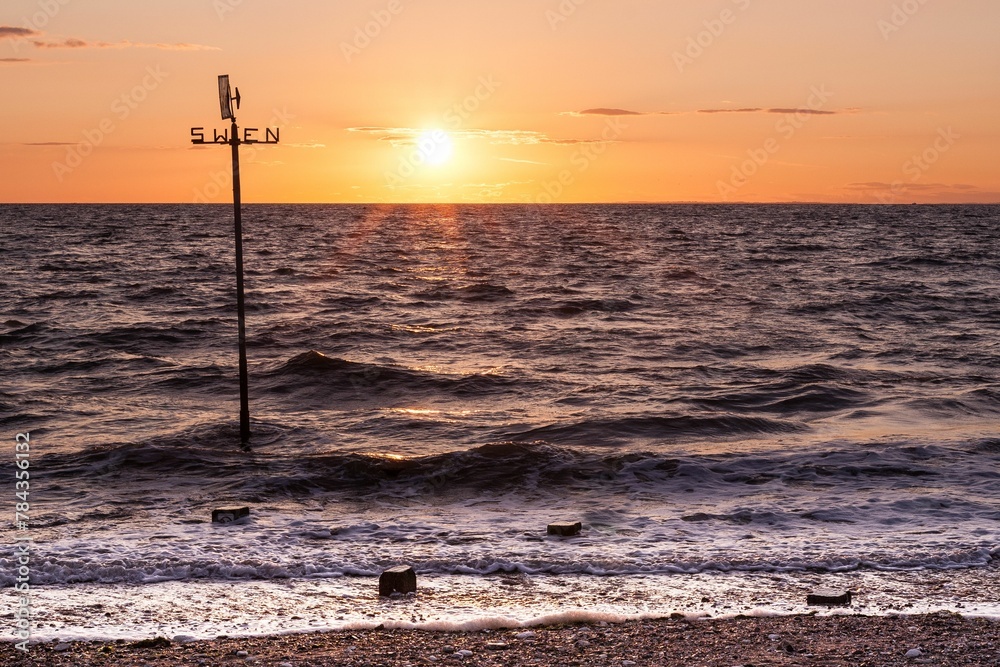 Golden sunset over Hunstanton Beach with a weathervane Golden sunset over Hunstanton Beach with a weathervane