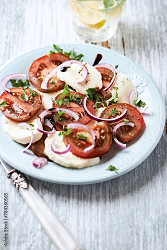 Summer Salad with Mozzarella Cheese, Tomatoes and red Onion. Wooden background. Close up. Copy space. 
