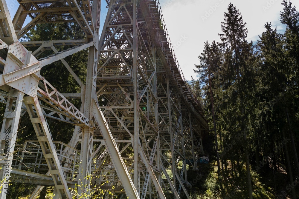 Closeup shot of a metallic construction surrounded by green trees, Ziemestal bridge