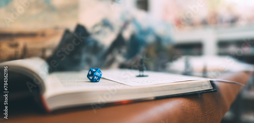 Blue dice D20 place on adventure story TTRPG book role playing tabletop game and board games photo