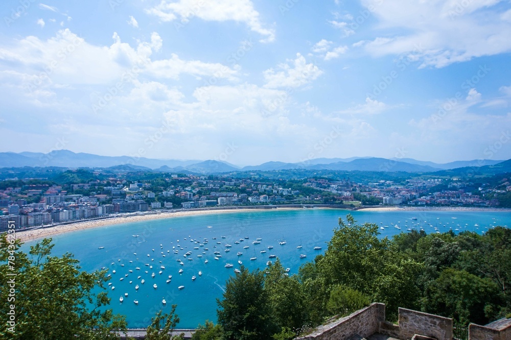 Obraz premium Scenic shot from the mount Urgull to the amazing cityscape of San Sebastian under blue cloudy sky