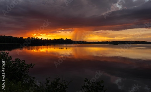 Beautiful view of a lake under the cloudy sky during orange sunset