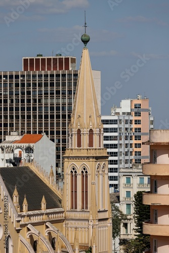 Vertical shot of a cathedral surrounded by modern buildings photo