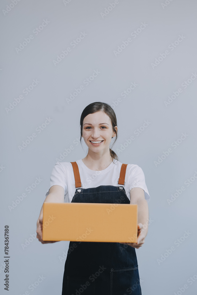 Smiling Asian woman in casual clothes holding a cardboard box mockup while standing against an isolated white background. shipping business concept Smiling Asian woman in casual clothes holding a cardboard box mockup while standing against an isolated white background. shipping business concept