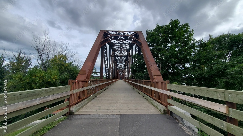 Wooden bridge with a metal structure over it