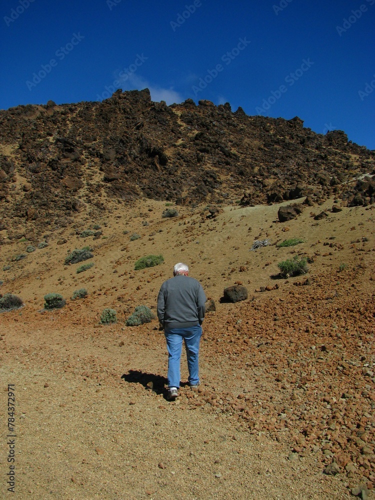 Vertical shot of the man in front of a Teide mountain in Tenerife, Canary Islands, Spain