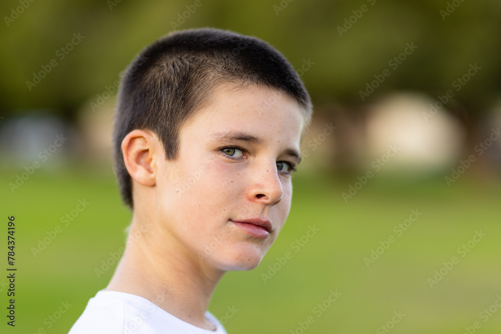 head and shoulders of tween child looking out corner of his eye with blurry background head and shoulders of tween child looking out corner of his eye with blurry background