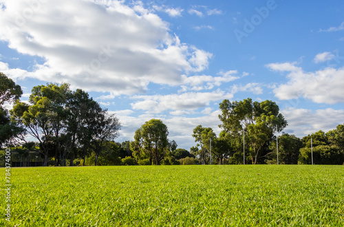 well tended grassed playing field with afl goalposts and trees in background