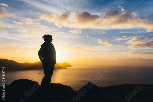 sunrise, dawn against the backdrop of mountains and ocean with the silhouette of a woman